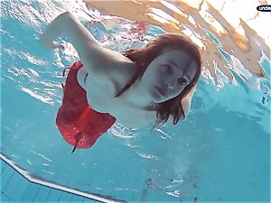 red clad nubile swimming with her eyes opened
